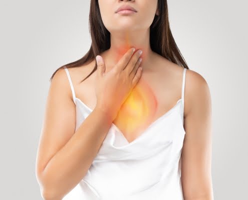 Doença do Refluxo Gastroesofágico (DRGE) 13 a woman suffering from acid reflux or heartburn on gray